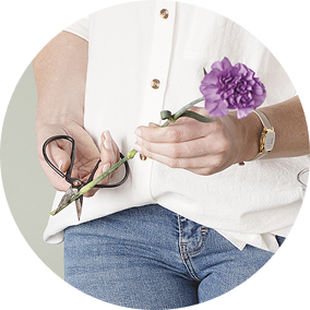 Woman cutting a flower stem with scissors